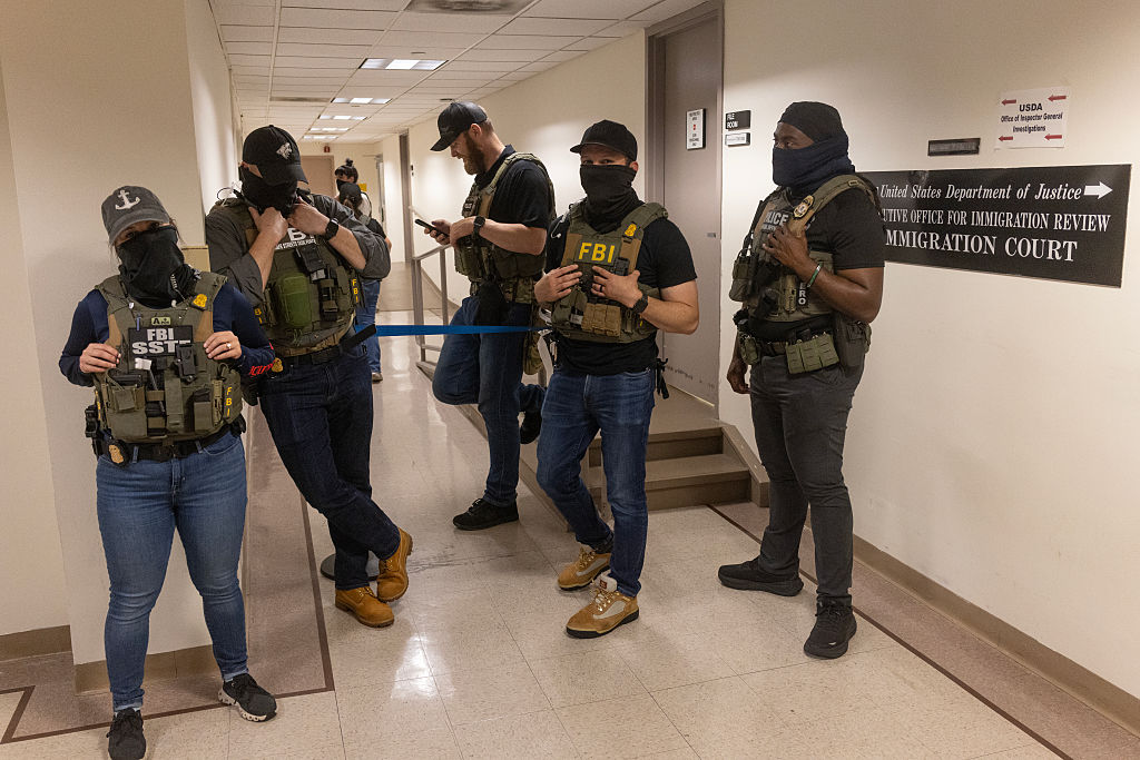 Federal agents wait in the hallways outside of immigration court to detain immigrants for deportation, June 18, 2025, at 26 Federal Plaza in New York City.