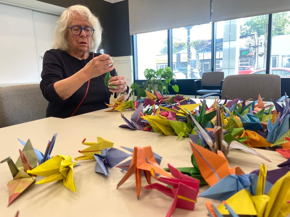 Judith Panson strings together paper cranes which will be sent to Hiroshima for the annual peace ceremony.