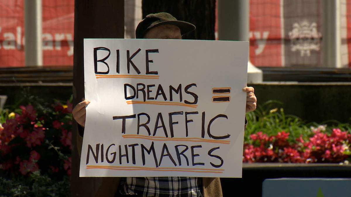 A protestor holding a sign protesting against any more bike lanes in Calgary, gathers outside a closed door meeting Wednesday, between the mayor of Calgary and Alberta's transportation minister, where the future of bike lanes was one of the main topics of discussion.