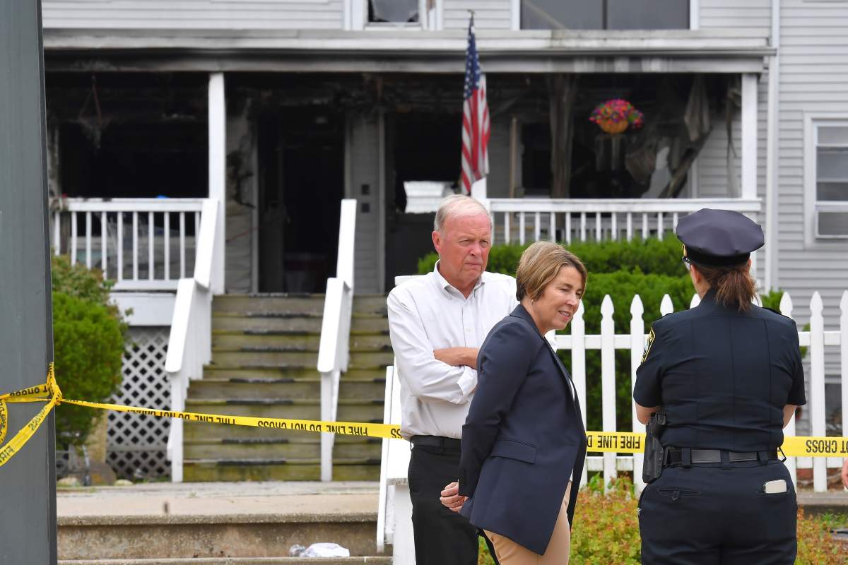 Massachusetts Gov. Maura Healey, center, and Fall River Mayor Paul Coogan, left, speak with a member of law enforcement, right, near the Gabriel House assisted living facility, Monday, July 14, 2025, following a fire that started late Sunday, in Fall River, Mass.
