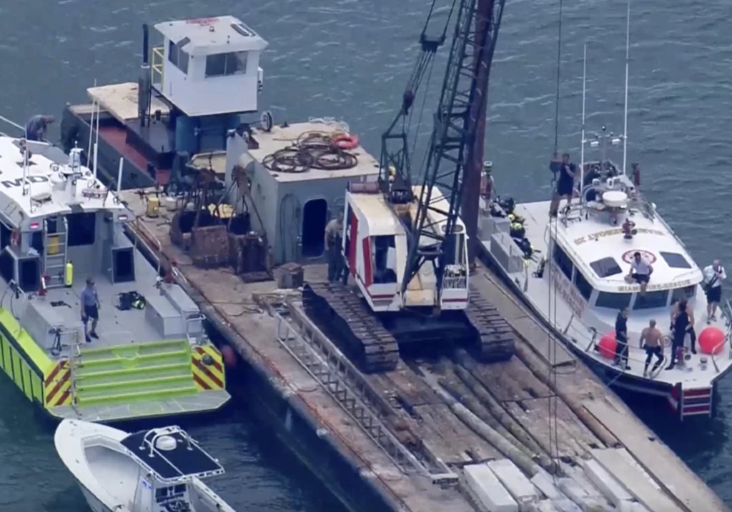 This image taken from video provided by WSVN-TV shows Miami-Dade Fire Rescue and others in boats around a barge involved in an accident with a group of kids and an adult on a sailing boat during sailing camp on July 28 in Miami.