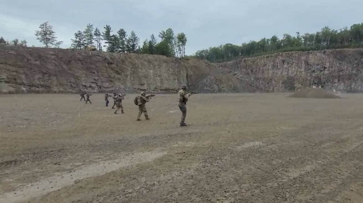 A photo provided by RCMP shows individuals standing in a large open area wearing military gear and holding what appear to be firearms.