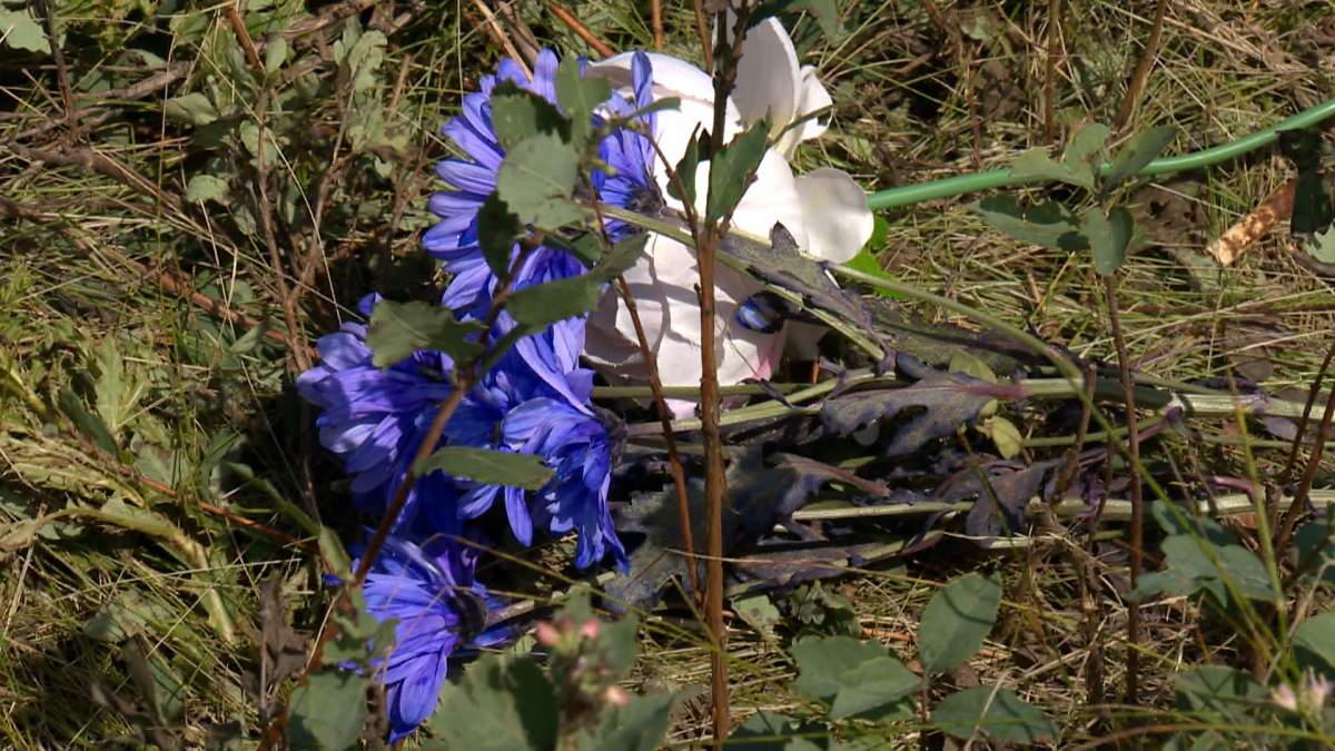 A bouquet of flowers lies alongside the road on the Siksika Nation near the spot where two pedestrians were killed and another sent to hospital in critical condition after they were struck by a vehicle on Saturday.