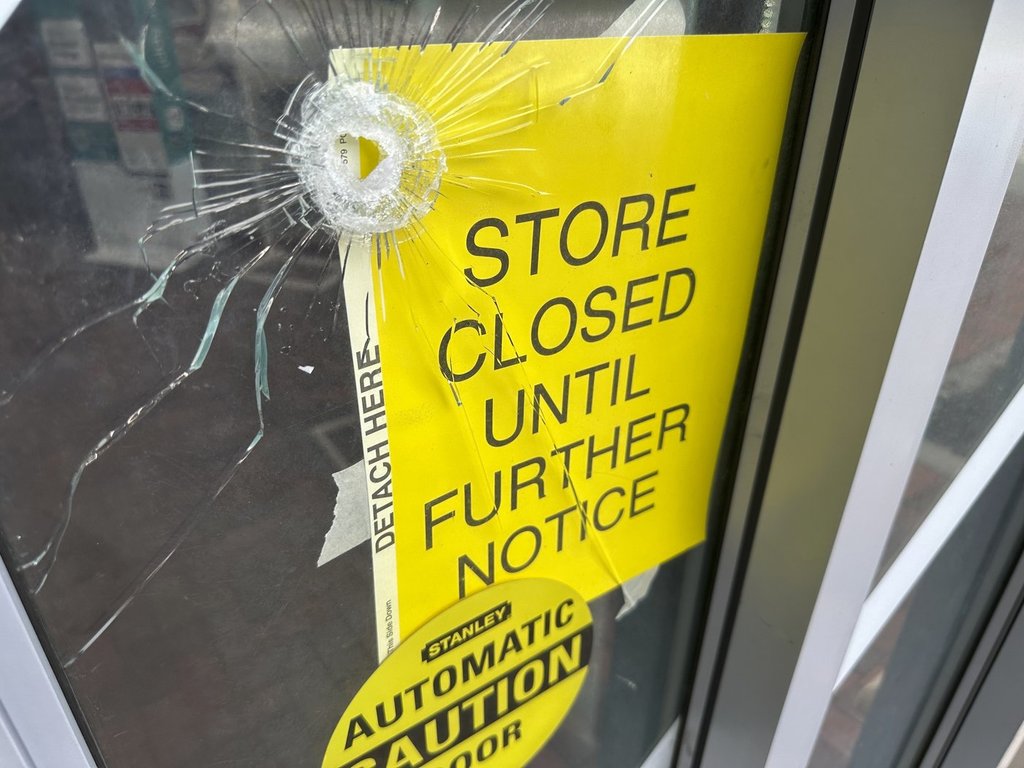 A bullet hole is visible in the door of a CVS pharmacy on Saturday, August 9, 2025, near where police say a man was shooting at the headquarters of the U.S. Centers for Disease Control and Prevention in Atlanta.