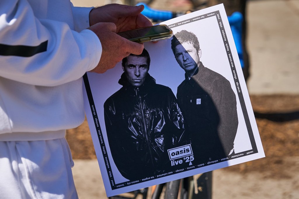 Oasis fans exit with official Oasis souvenirs on the second day of a clothing and merchandise pop-up store on Aug. 22, 2025, ahead of the band's concert at Rogers Stadium. THE CANADIAN PRESS/Sammy Kogan.