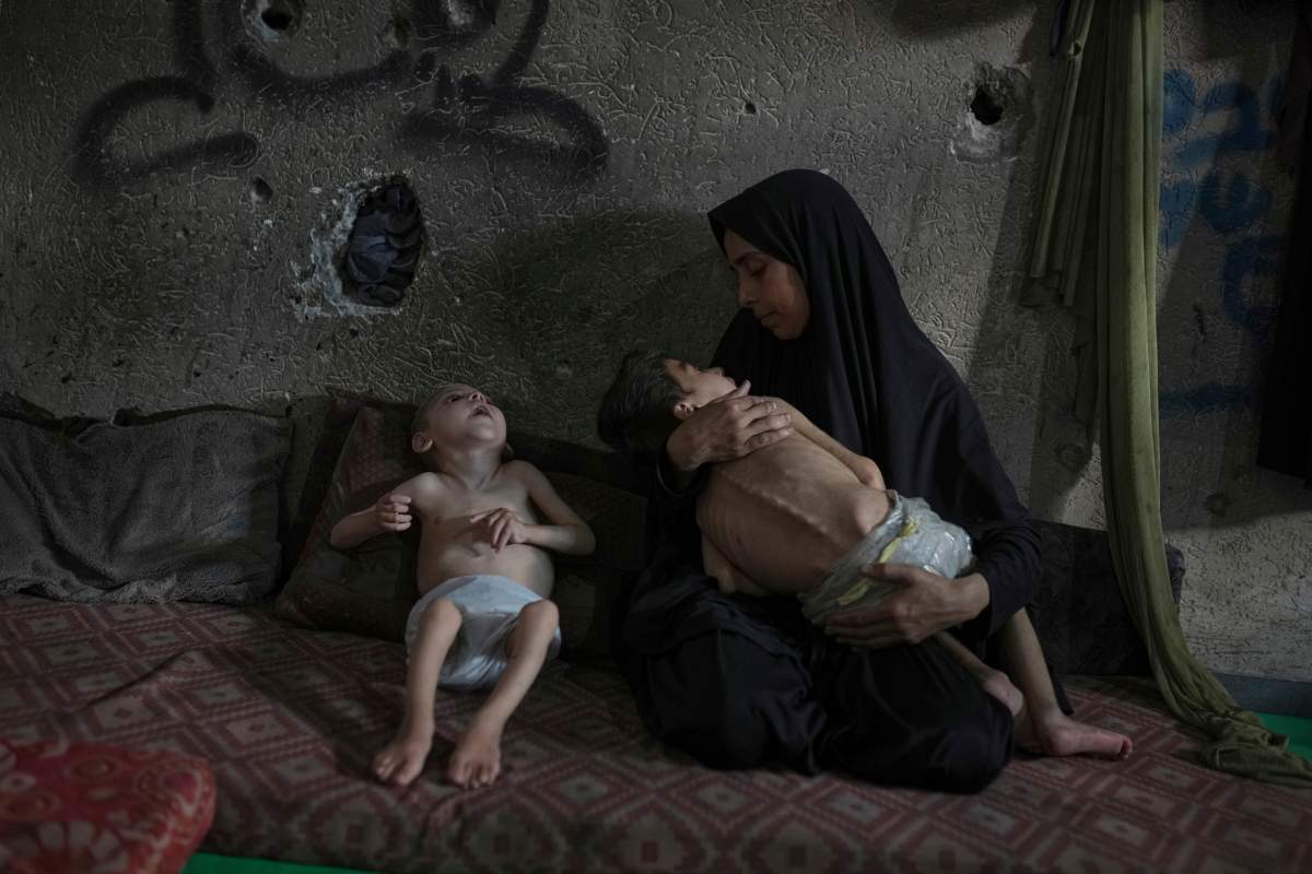 Samah Matar poses for a photo with her sons Yousef, 6, in her arms, and Amir, 4, who suffer from malnutrition and cerebral palsy, at a U.N.-run school in Gaza City, Saturday, July 26, 2025