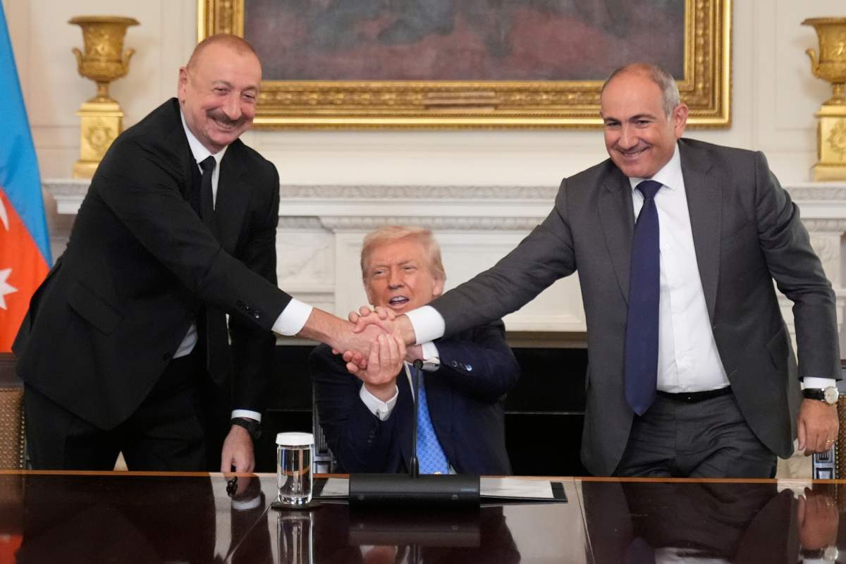 President Donald Trump, center, shakes hands with Armenian Prime Minister Nikol Pashinyan, right, and Azerbaijan President Ilham Aliyev during a trilateral signing ceremony in the State Dining Room of the White House, Friday, Aug. 8, 2025, in Washington. (AP Photo/Mark Schiefelbein).