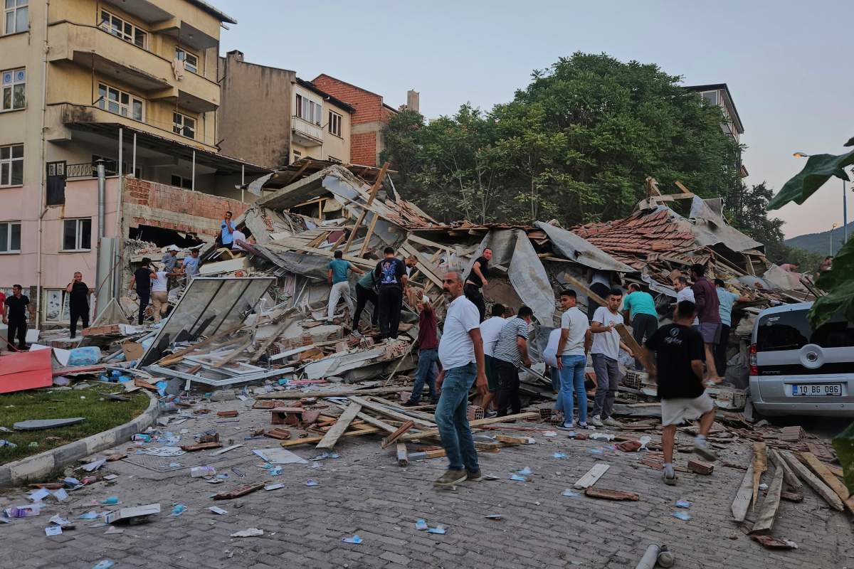 People remove the wreckage of a collapsed building following an earthquake in Sindirgi, northwest Turkey, Sunday, Aug. 10, 2025.