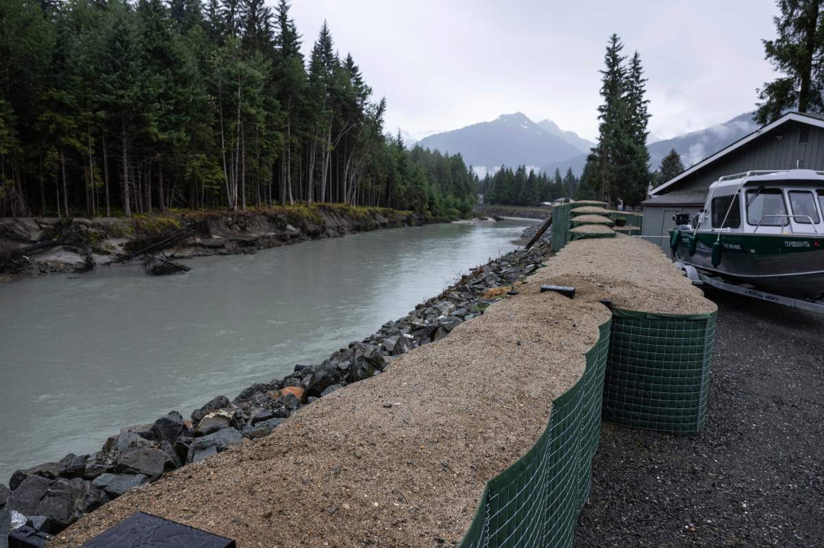 HESCO flood barriers, to protect property against glacial outburst flooding, separate a residential area from the Mendenhall River, Sunday, Aug. 3, 2025., in Juneau, Alaska. (Marc Lester/Anchorage Daily News via AP)