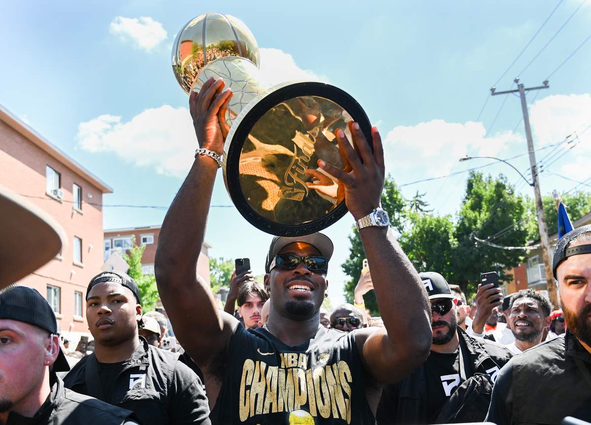 Oklahoma City Thunder guard Luguentz Dort, centre, carries the NBA’s Larry O’Brien trophy through the streets of Montreal North, Thursday, Aug. 21, 2025. THE CANADIAN PRESS/Graham Hughes