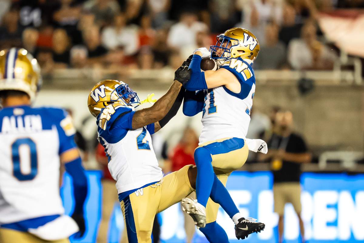 Winnipeg Blue Bombers' Evan Holm (right) intercepts a pass during first half CFL action against the Montreal Alouettes in Montreal on Thursday, Aug. 21, 2025. 