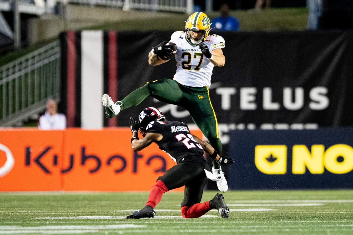 Edmonton Elks running back Tanner Green (27) leaps over Ottawa Redblacks defensive back Alijah McGhee (29) as he runs with the ball during first half CFL action in Ottawa, on Friday, Aug. 22, 2025.