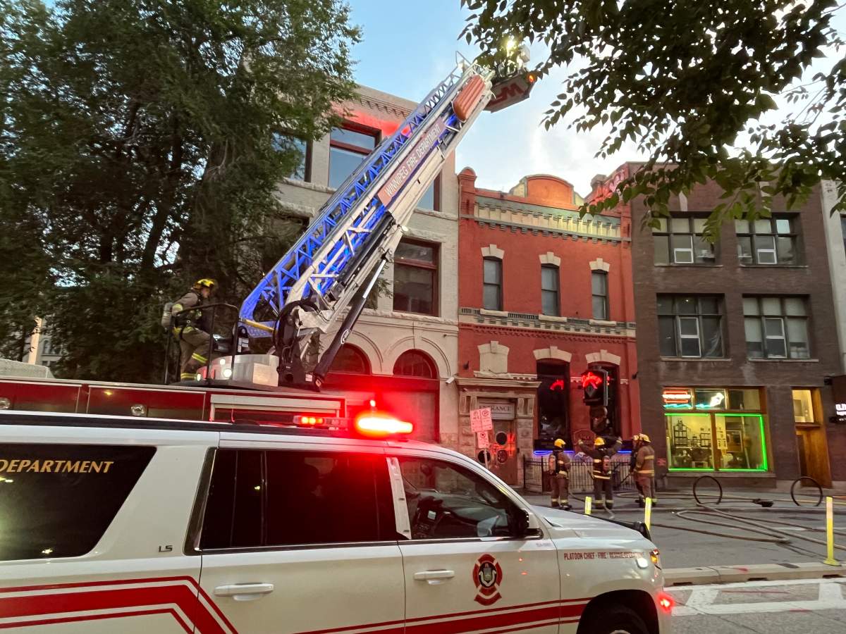 Winnipeg firefighters are seen outside Johnny G’s restaurant on McDermot Avenue on Wednesday morning.