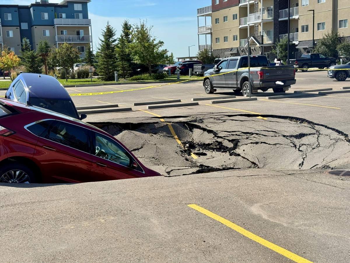 Two SUVs were left leaning into a sinkhole in the MacEwan Greens parking lot, located on the west side of Leduc, on Friday Aug. 1, 2025.