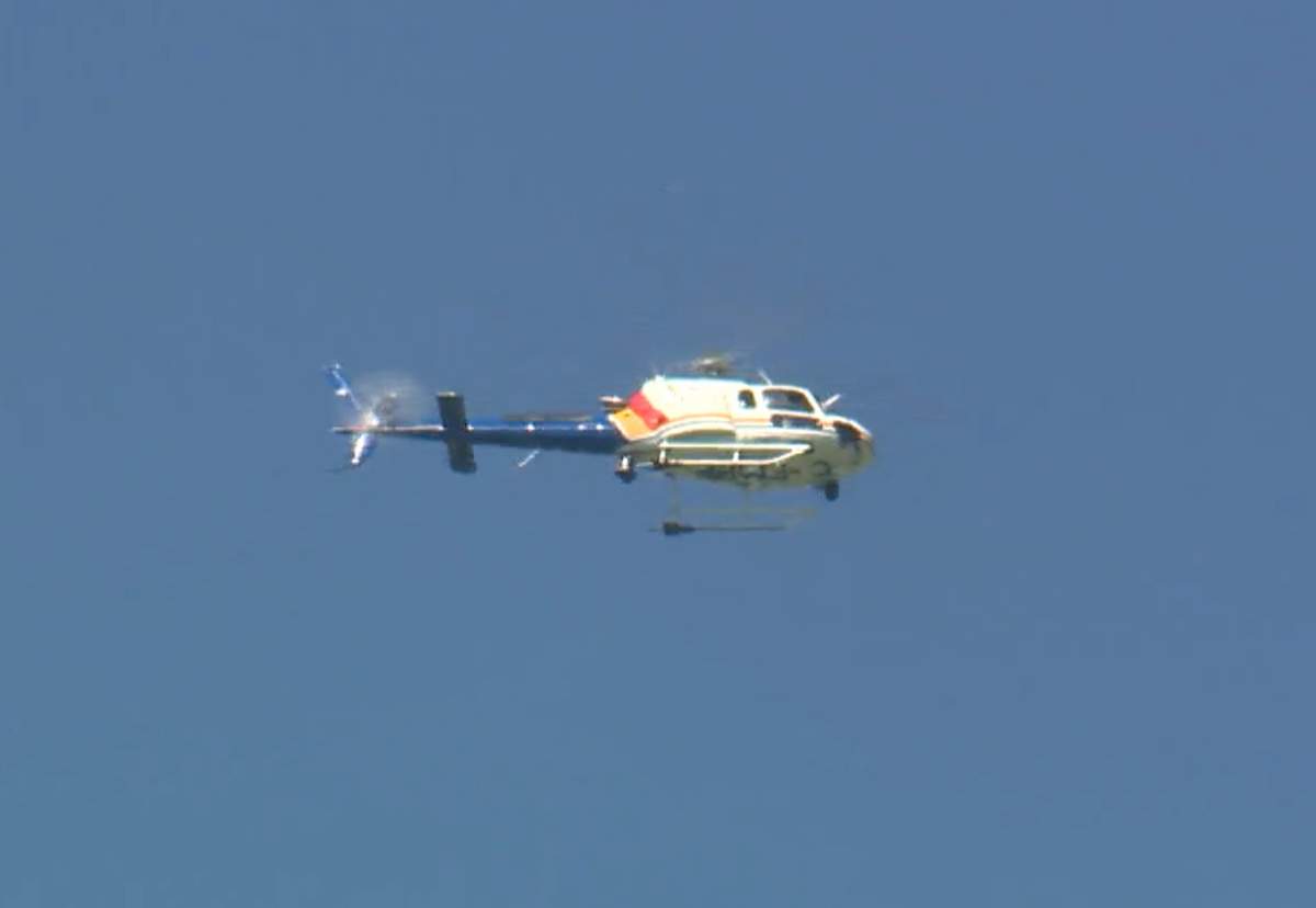 An Alberta RCMP helicopter is seen flying over an area just northwest of the town of Bowden, where a large contingent of police officers were "tracking a suspect."