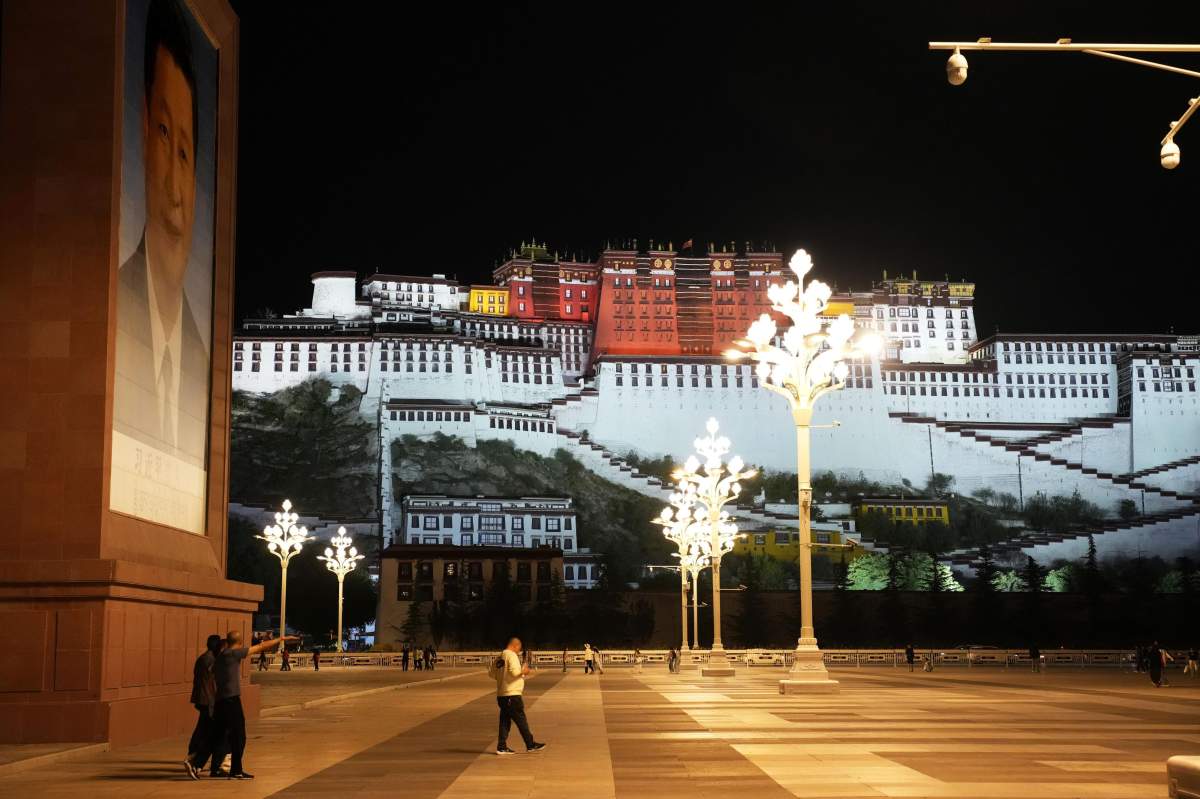 Chinese President Xi Jinping's portrait (L) is seen at a square near the Potala Palace (back) in Lhasa in the Tibet Autonomous Region on June 26, 2025.