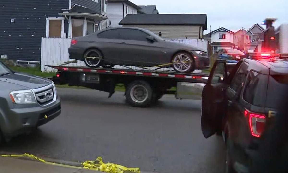 Calgary police tow a BMW from the scene of an overnight shooting in Taradale that sent two men to hospital in critical condition.