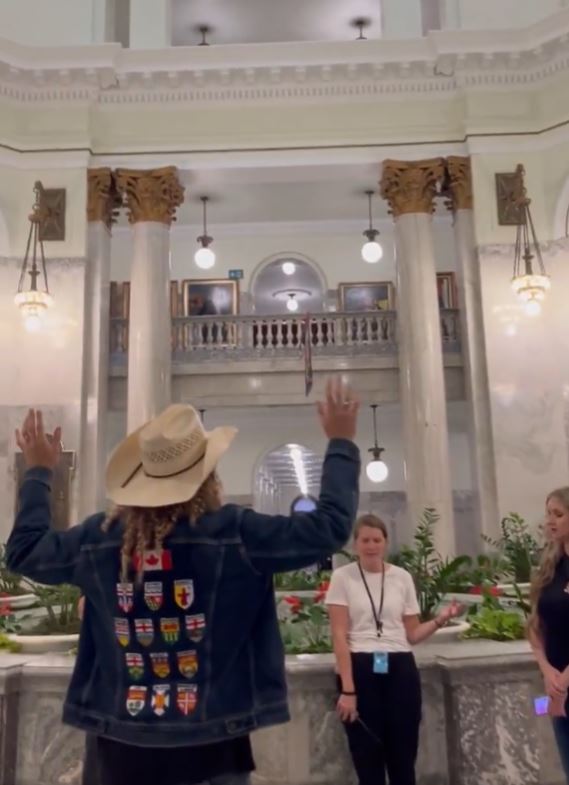 A screen grab from a social media post shows controversial American christian singer Sean Feutch leading a "worship session" in the rotunda of the Alberta legislature after being let into the building by family services minister Searle Turton on Friday.