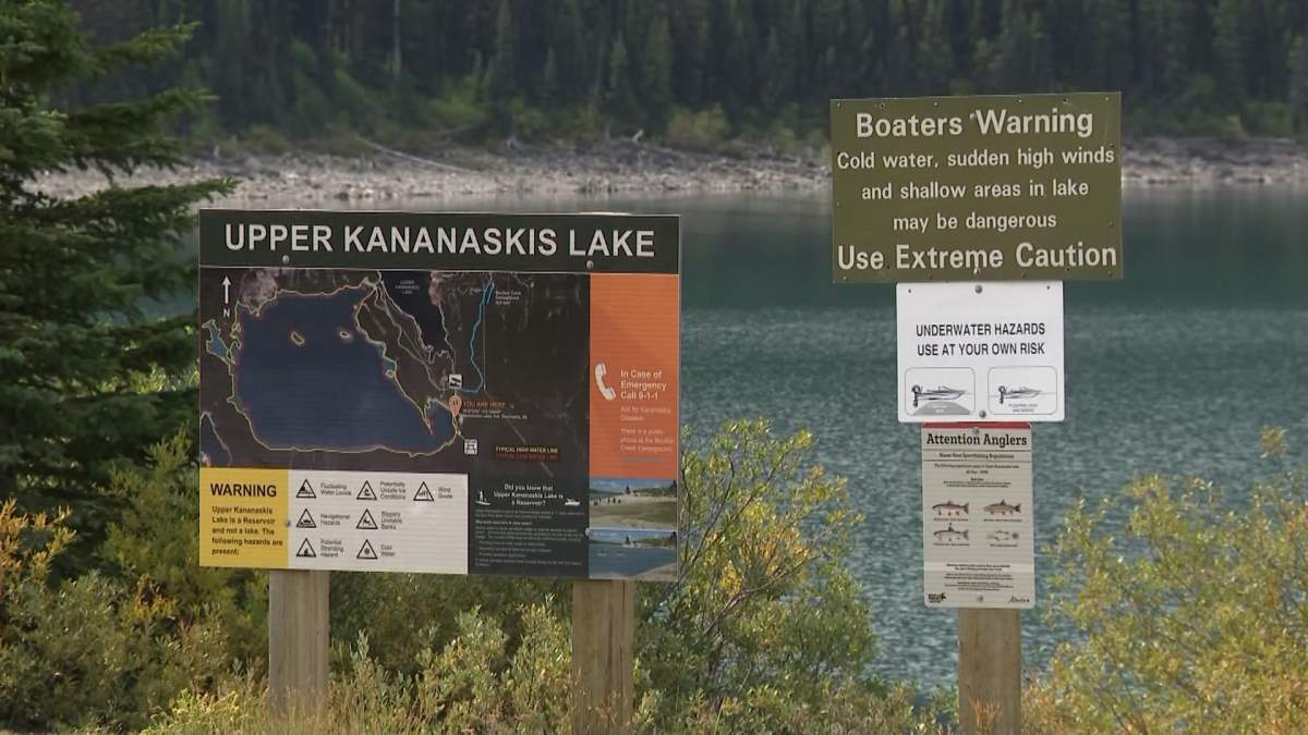 Signs along the shore of Upper Kananaskis Lake warning boaters of the dangers of cold water and sudden high winds and urging them to wear a lifejacket.