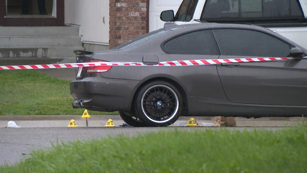 Calgary police evidence markers surround a vehicle in Taradale that the two men appear to have been sitting in when they were shot.