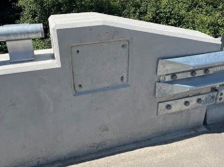 A picture of the concrete side of a bridge focused on the space where a plaque used to be.