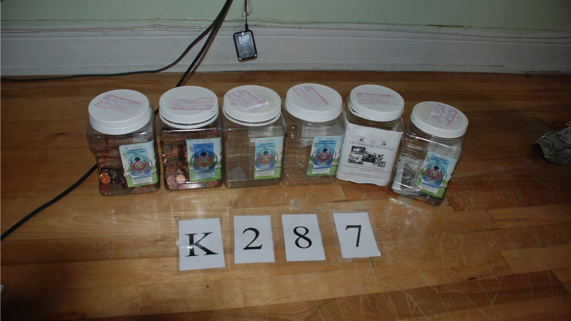 Police photo taken during search of World Tamil Movement office in Quebec shows collection jars.