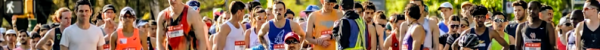 Photo of Kyle Gieni in wheelchair with marathon participants in background.