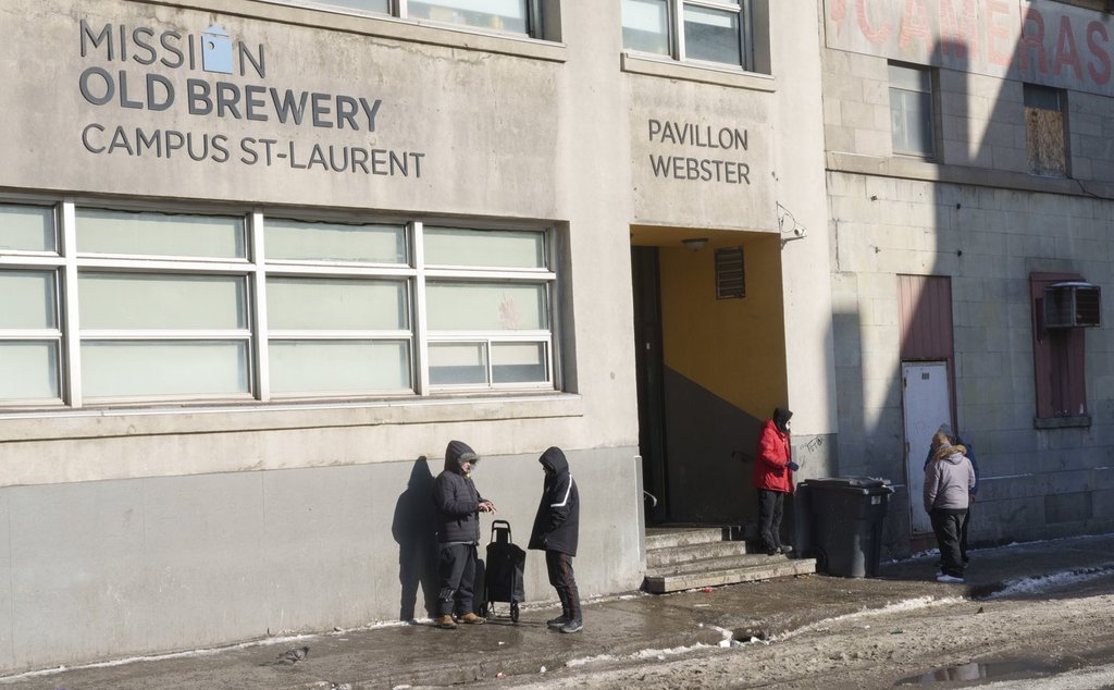 People stand outside the Old Brewery Mission in Montreal, Monday, Jan. 10, 2022. THE CANADIAN PRESS/Paul Chiasson.