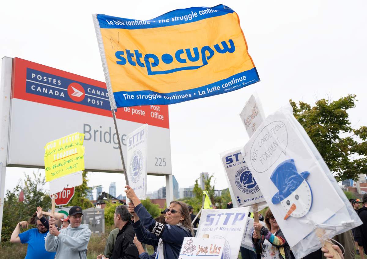 Canada Post workers picket outside a distribution centre as part of a strike action in Montreal on Friday, Sept. 26, 2025.