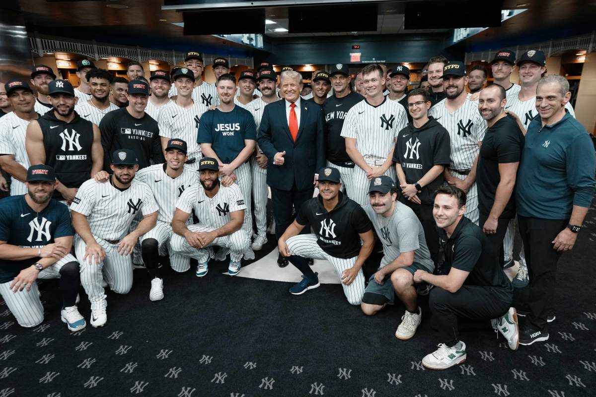 U.S. President Donald Trump poses with members of the New York Yankees in the locker room before a game against the Detroit Tigers at Yankee Stadium on September 11, 2025 in New York City.