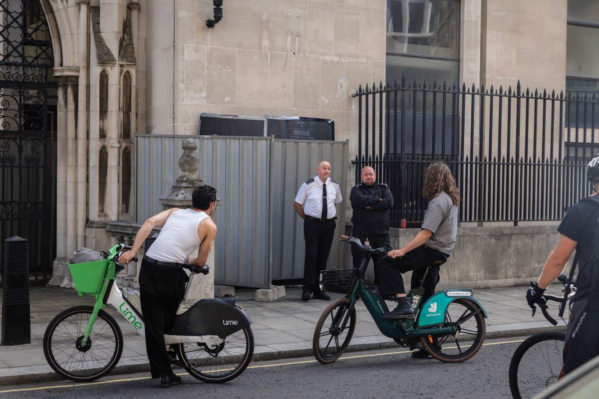 People who had come to see a new Banksy mural, ask Security guards standing in front of it at The Royal Courts of Justice, why it has been covered up on September 8, 2025 in London, England.