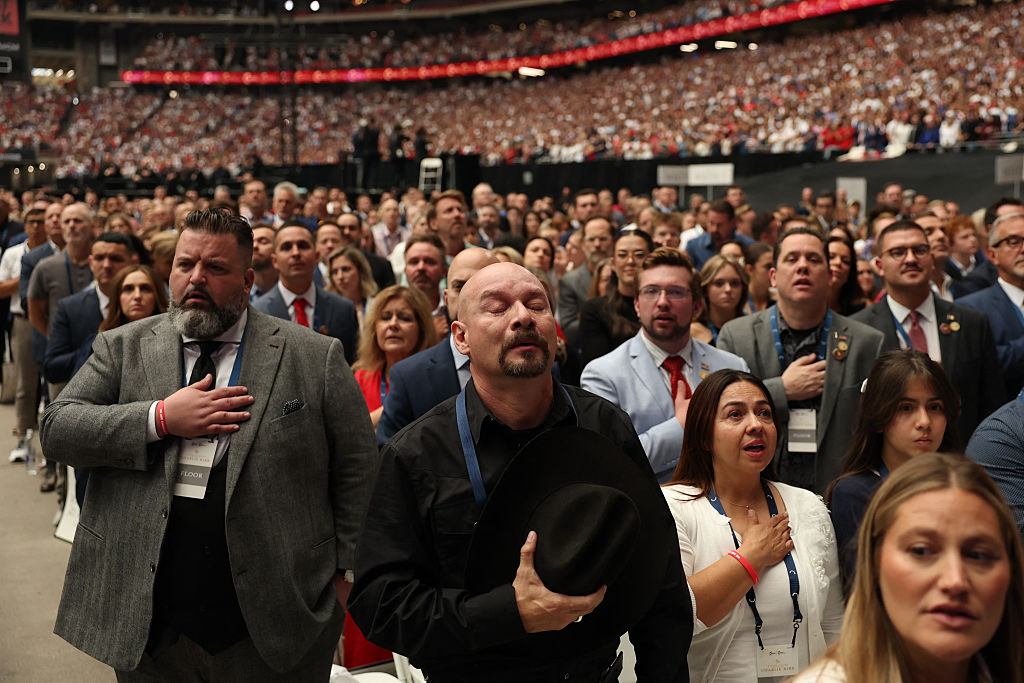 Attendees pray during the public memorial service for right-wing activist Charlie Kirk at State Farm Stadium in Glendale, Arizona, on September 21, 2025.