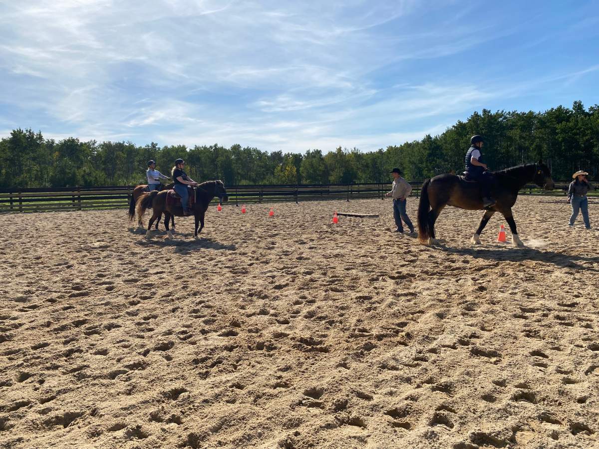 Sylvie Desmarais (right) and other riders take lessons on their horses at Red Rose Ranch