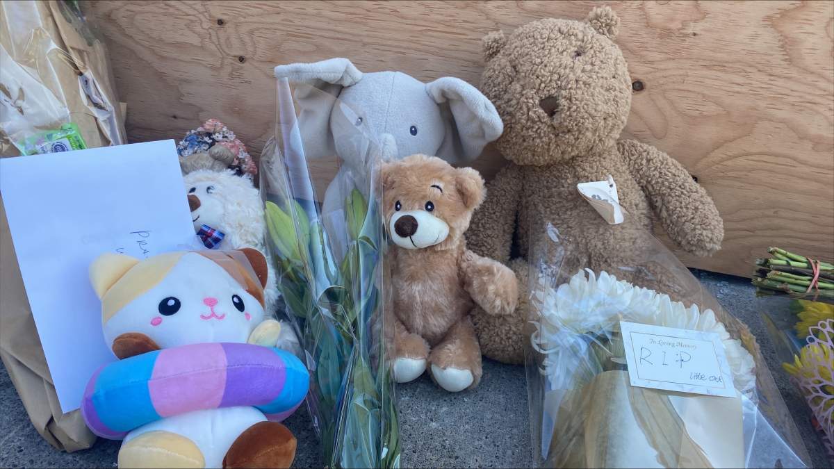 A collection of stuffed animals, flowers and letters were set up in front of the daycare.