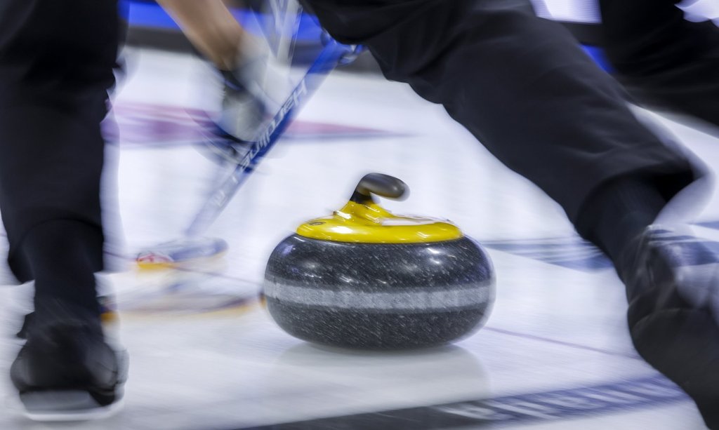 Players sweep a rock at the Tim Hortons Brier in Lethbridge, Alta., Sunday, March 6, 2022. A network of curling high-performance training centres in Canada has been created with expansion to Victoria, Okotoks, Alta., Moose Jaw, Sask., and Kitchener-Waterloo, Ont.    THE CANADIAN PRESS/Jeff McIntosh.
