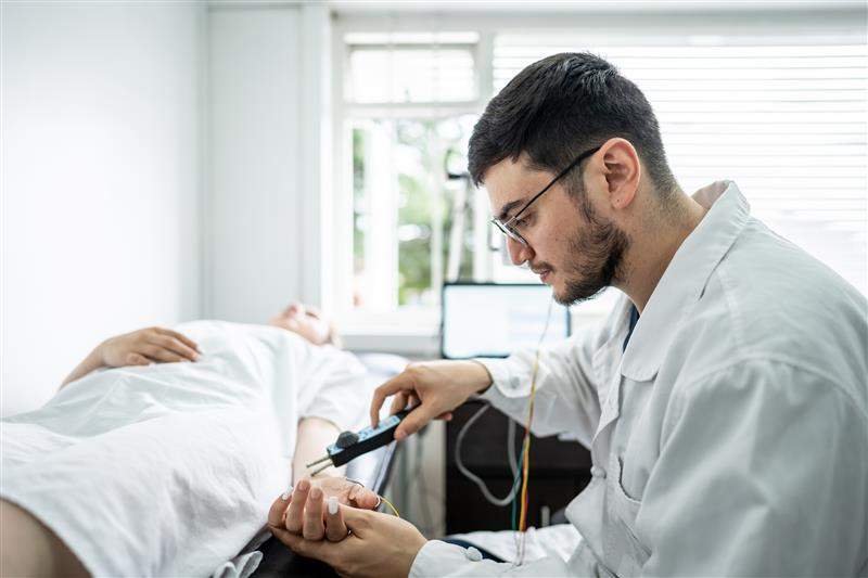 A doctor uses a device to examine a patient’s nervous system. Frazao Studio Latino/Getty Images