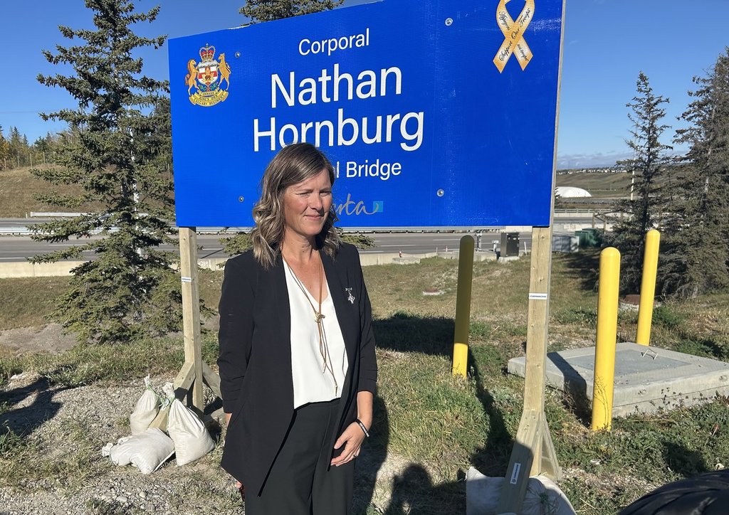 Rachel Herbert stands before a Calgary bridge being named in honour of her brother, Cpl. Nathan Hornburg on Wednesday, Sept. 24, 2025. The reservist from Calgary was killed in 2007 while working to recover a disabled tank under fire by the Taliban in Afghanistan. 