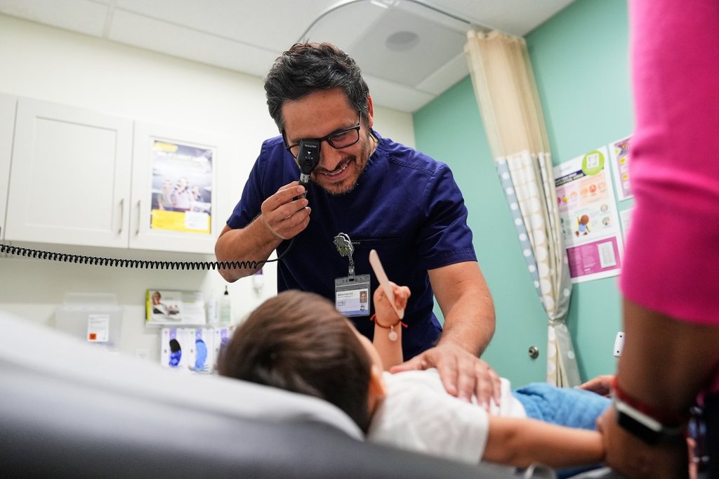FILE - Pediatrician Irving Phillips, left, examines a 16-month-old boy at a CommuniCARE+OLE clinic, June 26, 2025, in Davis, Calif. (AP Photo/Godofredo A. Vásquez, File).