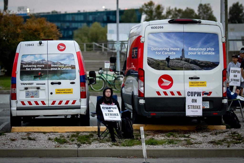 A member of the Canadian Union of Postal Workers pickets outside of a Canada Post Centre in Richmond, B.C. on Friday, Sept. 26, 2025. THE CANADIAN PRESS/Ethan Cairns