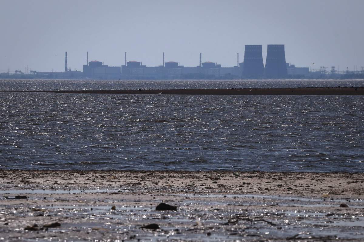 The Zaporizhzhia nuclear power plant, Europe's largest, is seen in the background of the shallow Kakhovka Reservoir after the dam collapse, in Energodar, Russian-occupied Ukraine, Friday, June 9, 2023. The plant has been under Russian occupation since 2022.