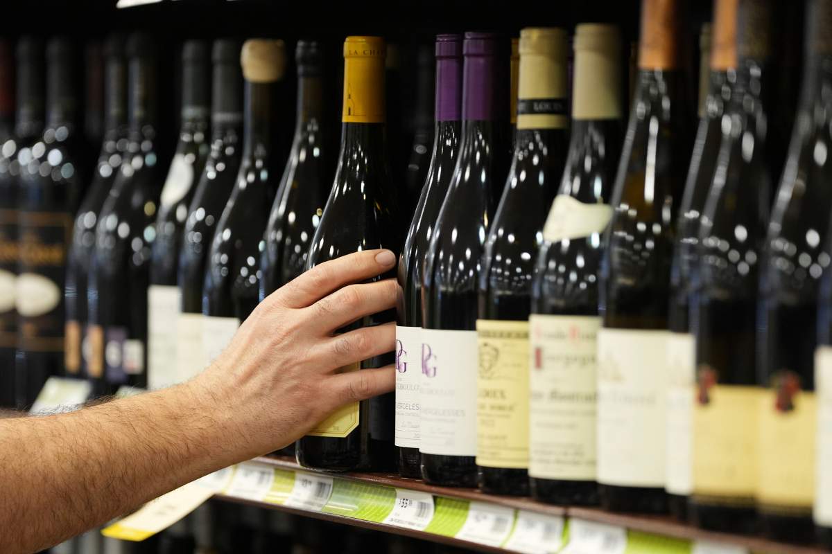 A clerk stocks French wines at a Pennsylvania Fine Wine & Good Spirits in Flourtown, Pa., Thursday, March 13, 2025.