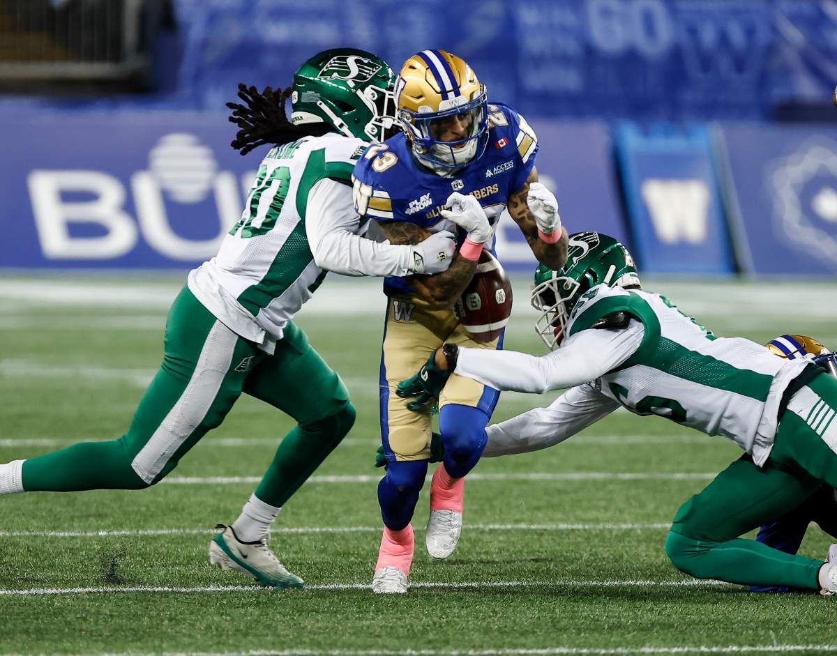 Winnipeg Blue Bombers’ Trey Vaval (23) fumbles the ball as he is tackled on the opening kick return by Saskatchewan Roughriders’ Kerfalla Exumé (20) during first half CFL action in Winnipeg, Friday, Oct. 17, 2025. THE CANADIAN PRESS/John Woods.