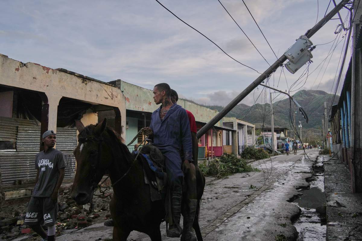 Men ride after the passage of Hurricane Melissa in El Cobre, Cuba, Wednesday, Oct. 29, 2025.