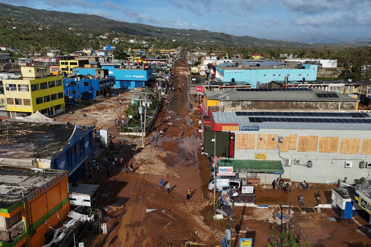 Residents walk through Santa Cruz, Jamaica, Wednesday, Oct. 29, 2025, after Hurricane Melissa passed.