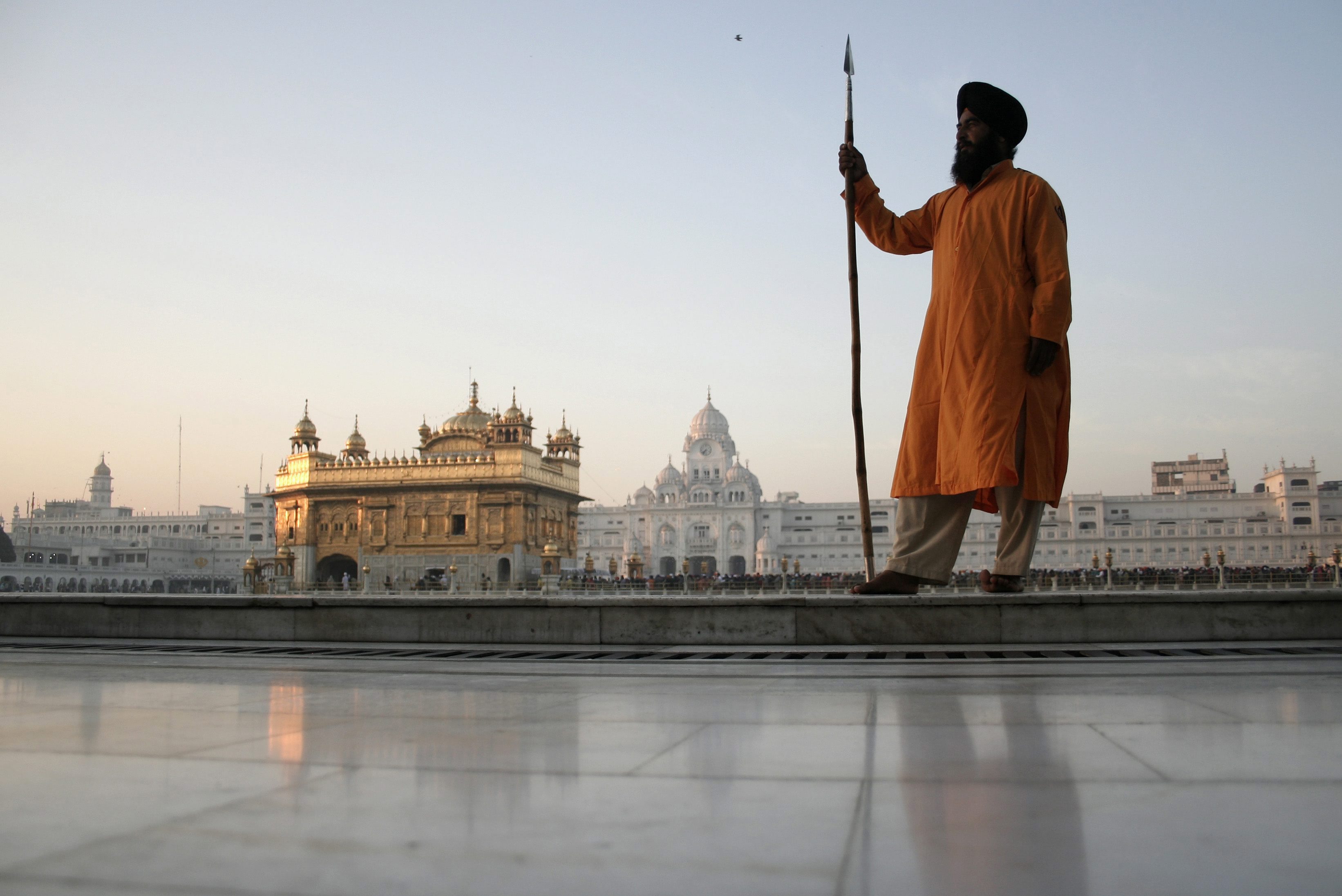 A Sikh volunteer stands guard near the sacred pond of the Golden Temple, Amritsar, India, Nov. 21, 2010. (AP Photo/Sanjeev Syal)