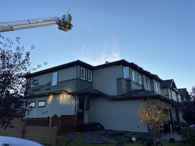 Firefighers work on a duplex fire in south Edmonton on Oct. 5, 2025.
