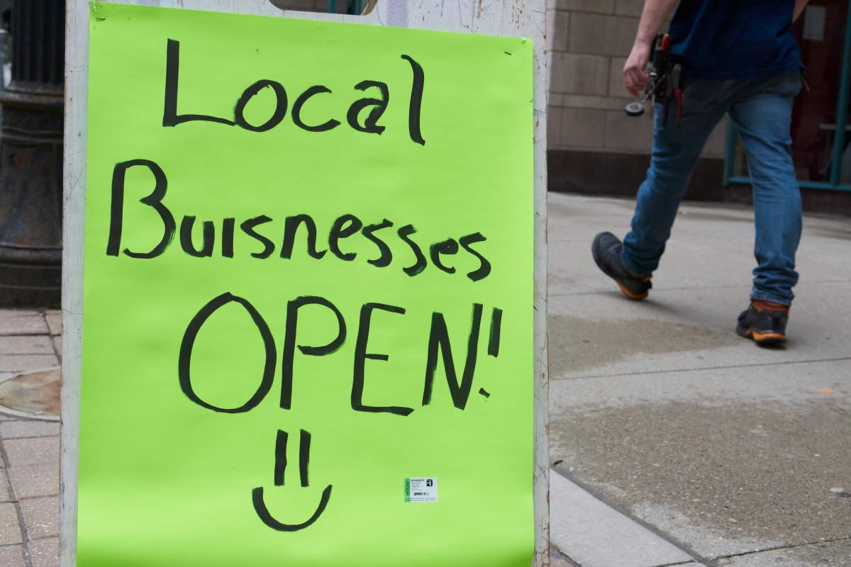 A “local businesses open” sign is seen in Toronto on May 26, 2021.