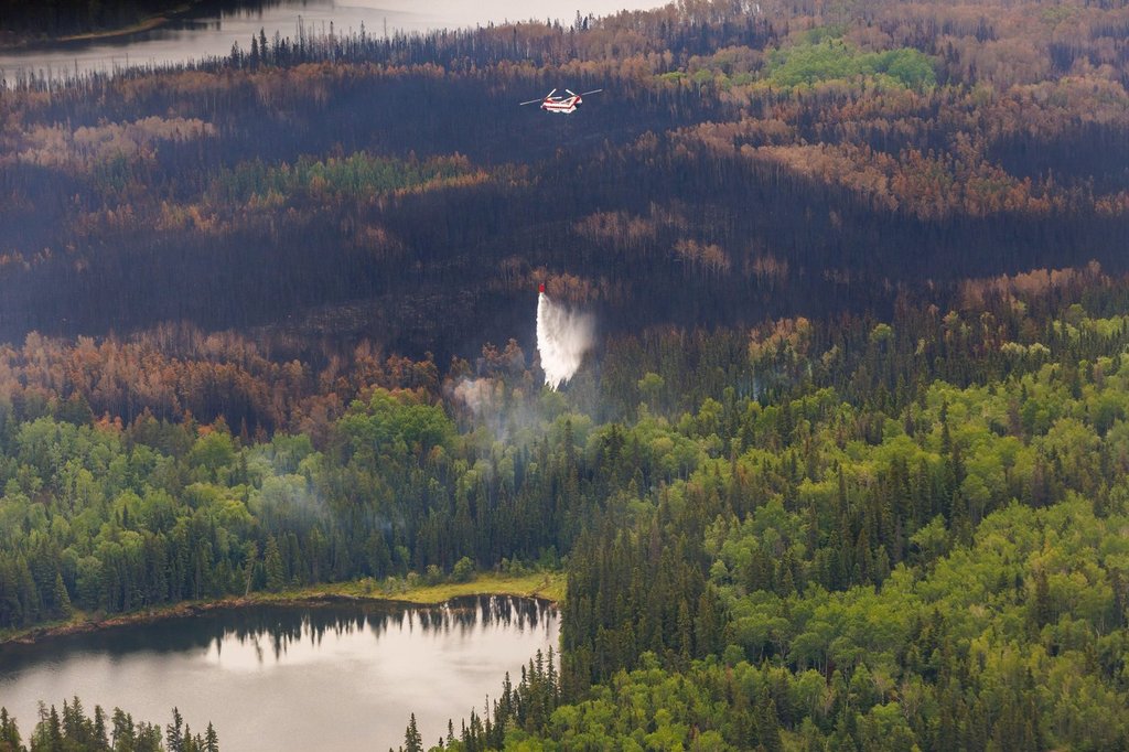 A helicopter crew works on a wildfire in northern Manitoba during a helicopter tour in the surrounding area of Flin Flon, Man., on Thursday, June 12, 2025. THE CANADIAN PRESS/Mike Deal-Pool.