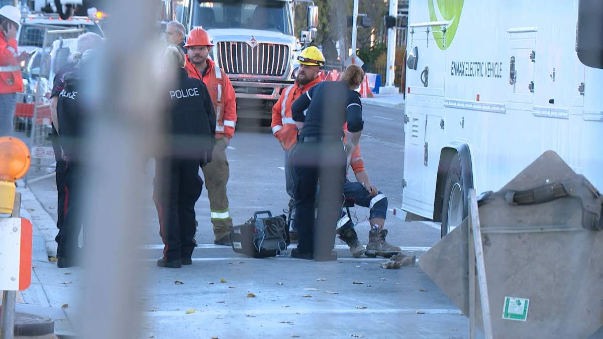 Paramedics are seen treating a worker at the scene of an explosion in southeast Calgary early Thursday morning.