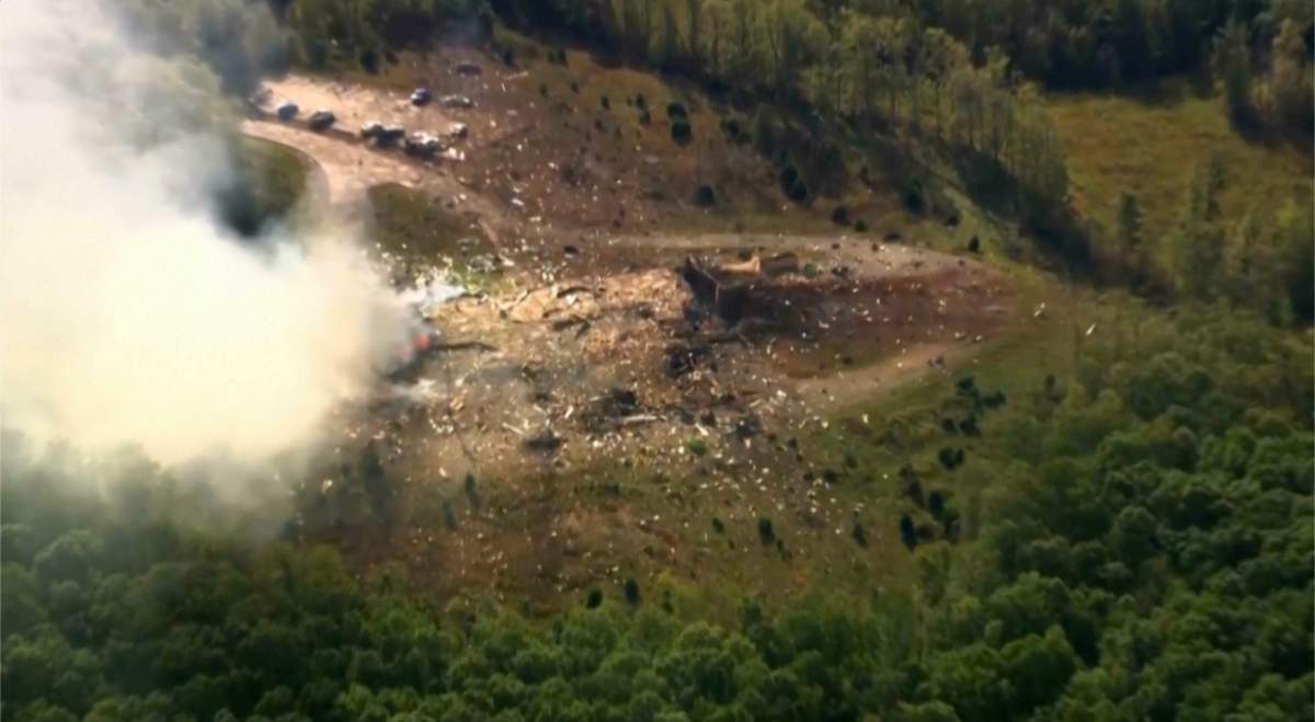 Smoke fills the air as debris covers the ground and vehicles after a powerful blast ripped through a military explosives manufacturing plant in Hickman County, Tenn., on Friday, Oct. 10, 2025. (WTVF-TV via AP)